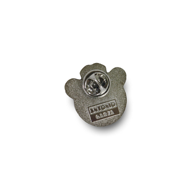 Photo of the back of the emoji pin, with pin clamp..  text Antonio Garza can be seen embossed on back.