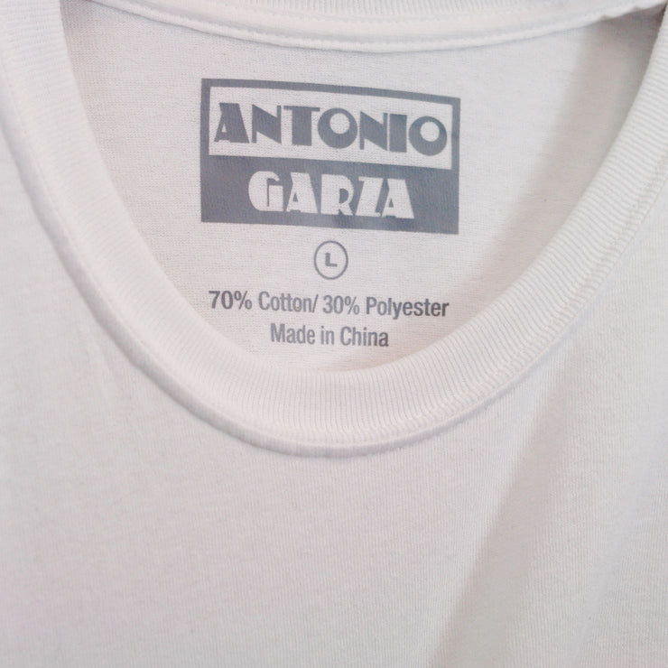 Close up of the inside neck print in gray text "Antonio Garza" "L""70% Cotton/30% Polyester""made in china" on a white tee.